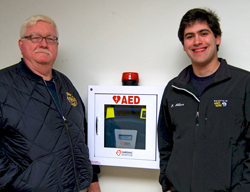 EMT instructor Chuck Holyfield (left) and EMS club president Ben Allar '13 with Connecticut College's new Automated External Defibrillator (AED)