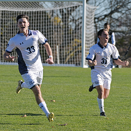 Members of the mens soccer team celebrate a goal during a match.