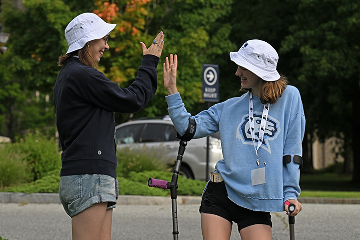 Student leaders high five before welcoming new students to campus.