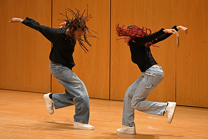 two student dancers perform hip hop routine on stage