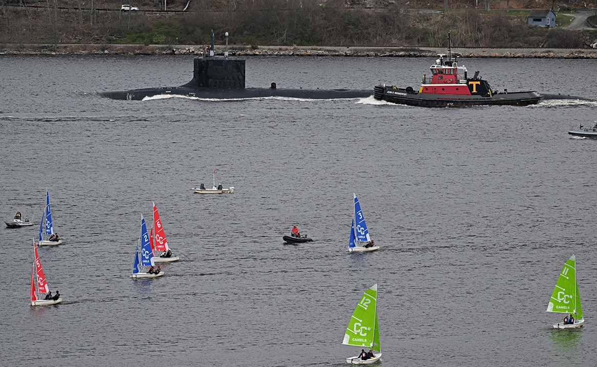 A submarine passes a group of small sailboats.